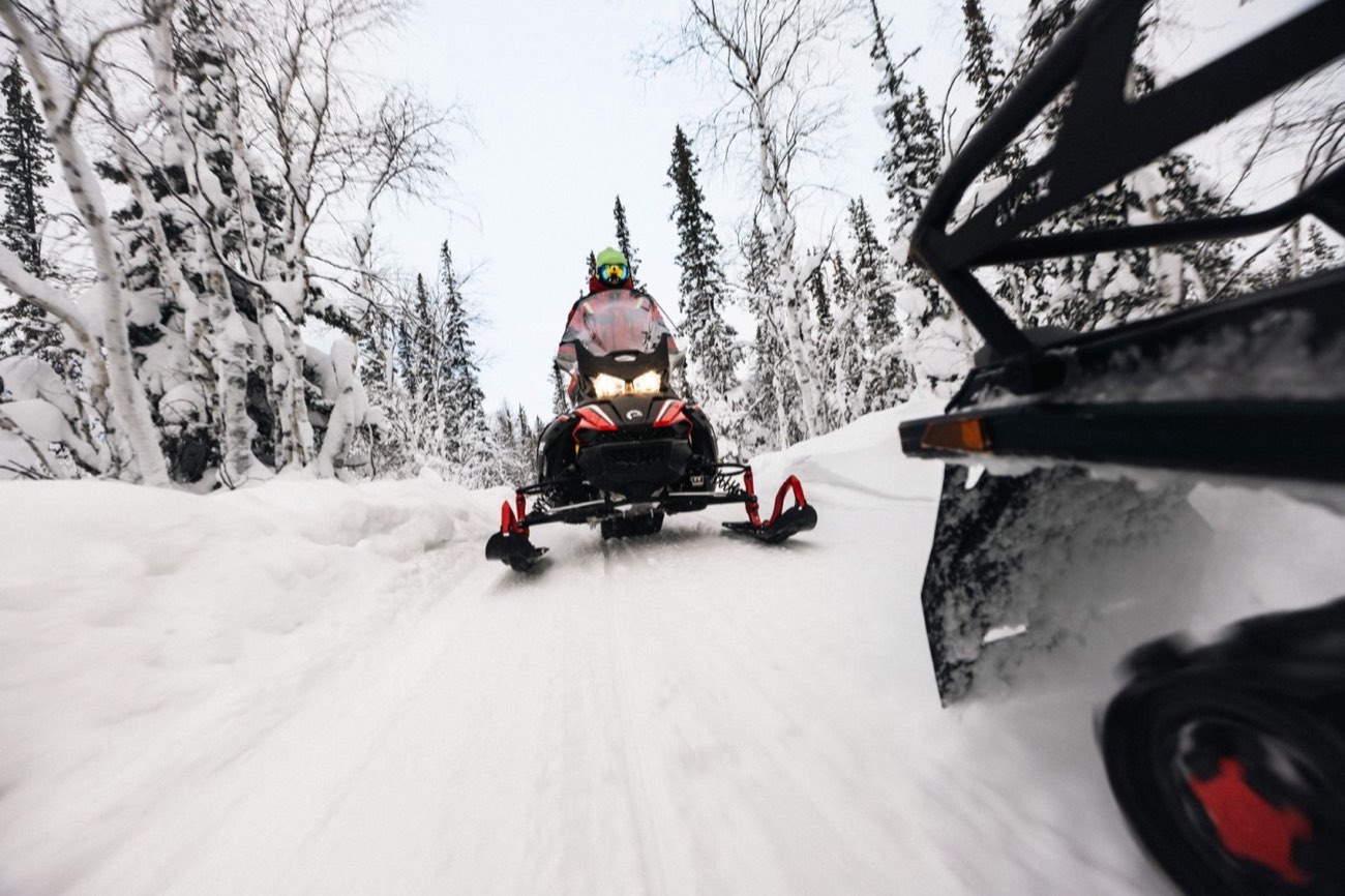 Snowmobiler riding a snowy forest trail
